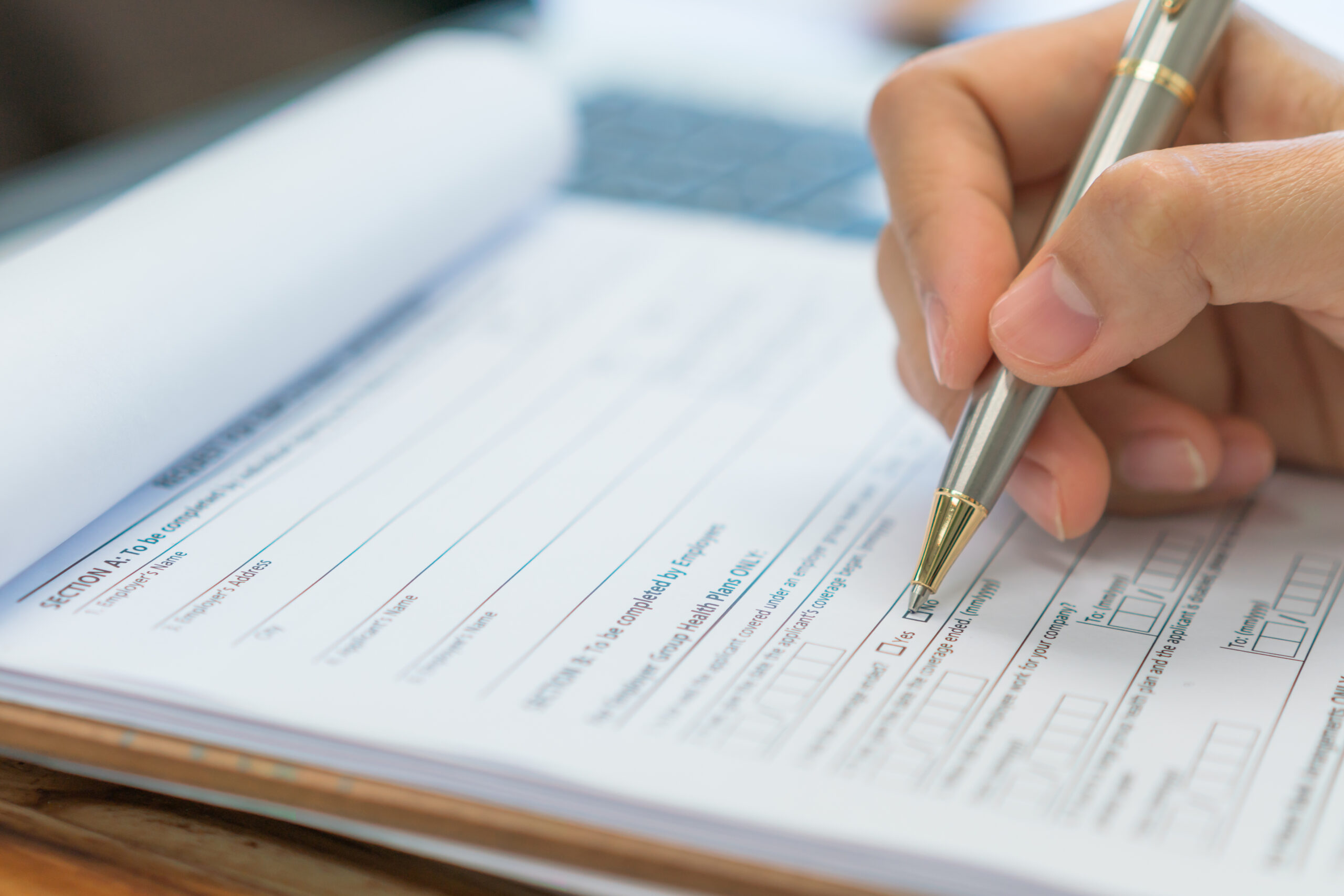 Hand with pen over application form